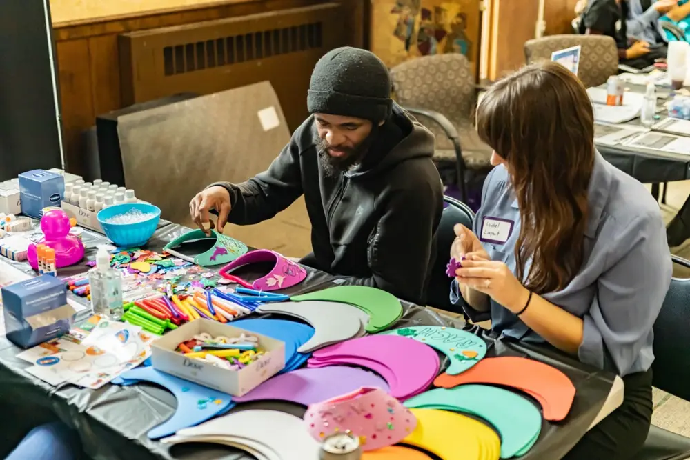 Hands-on creative engagement at a Neighborhood House health fair exhibit table