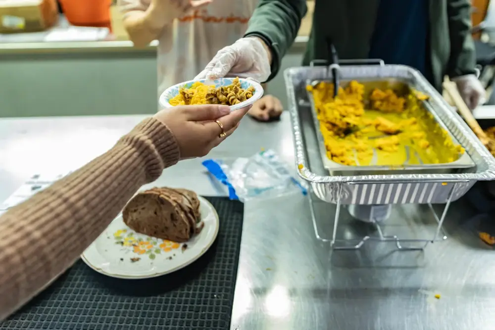 A freshly prepared meal being handed to another person at the health fair
